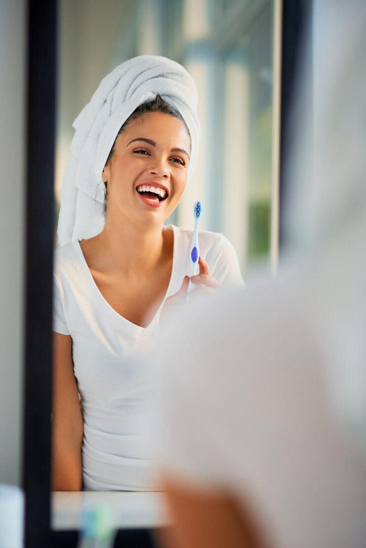 Foto spazzolare i denti specchio e sorriso con la donna nel bagno di casa per l'igiene mattutina o la cura dentale spazzolino da denti e riflesso con persona felice in appartamento per la pulizia dei denti mattutina