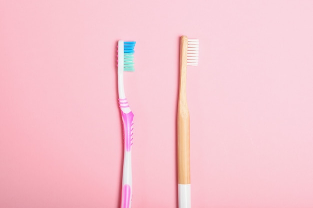 Spazzolini da denti in bambù naturale e plastica su uno sfondo colorato vista dall'alto