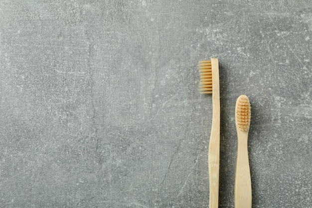 Spazzolini da denti in legno ecologici su sfondo grigio