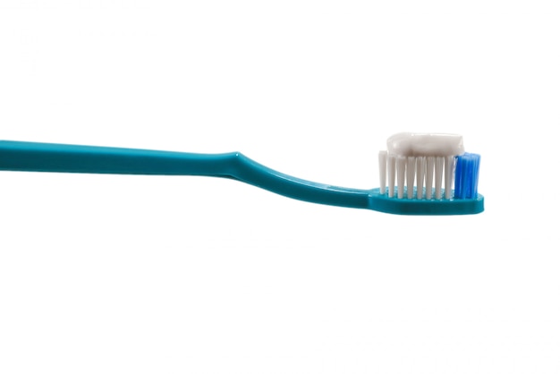 Spazzolino da denti blu con dentifricio in pasta isolato su bianco.