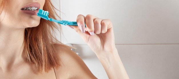 Spazzolino da denti della holding della giovane donna prima di lavarsi i denti