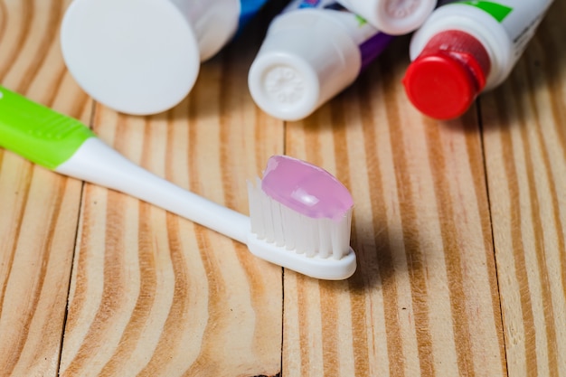 spazzolino da denti e dentifricio su fondo in legno.