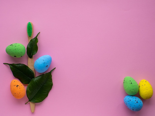 Spazzolino da denti in legno con decorazioni pasquali su sfondo rosa