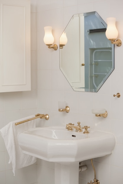 Specchio con lampade accese sopra il lavandino in bagno