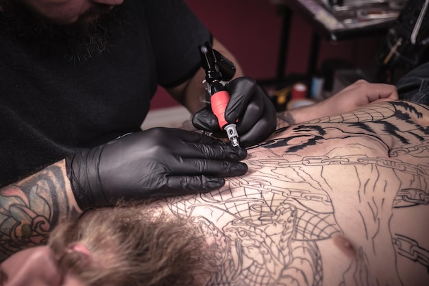 Specialista del tatuaggio si è concentrato sul suo lavoro in uno studio di officina.