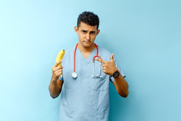 Specialista in urologia maschile latinoamericana in possesso di un organo maschile di banana e concetto di prostata