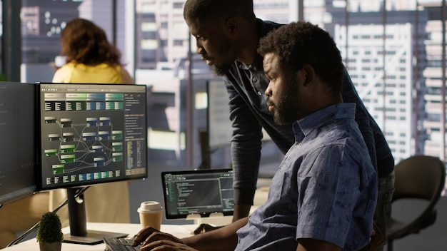 Specialista IT assistito da un collega per confrontare i dati in ufficio