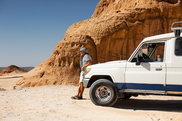 Spedizione in auto SUV in un deserto di pietra dell'Egitto. Paesaggio di montagna con fuoristrada.