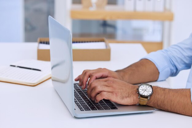 Sperando di riuscire a risolvere il problema in tempo Inquadratura di un uomo d'affari che scrive sul suo laptop