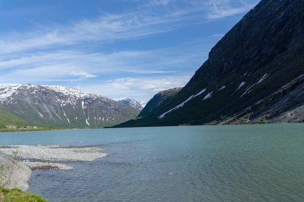 Spettacolare lago del ghiacciaio Nigardsbreen senza nessuno con montagne innevate in Norvegia