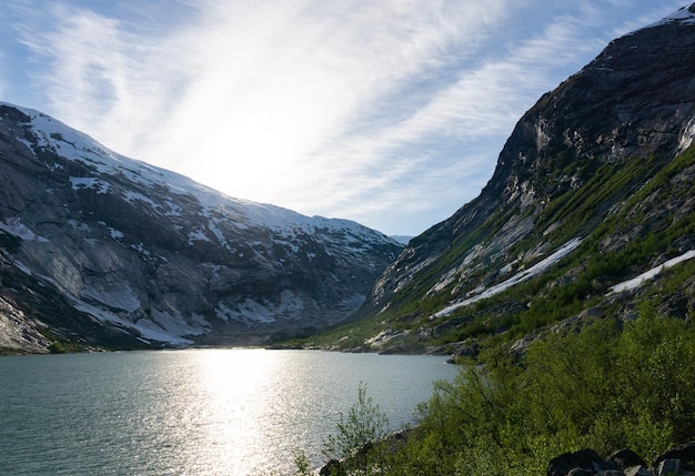 Spettacolare lago del ghiacciaio Nigardsbreen senza nessuno con montagne innevate in Norvegia