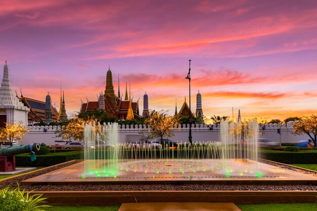 Spettacolo di fontane con il tempio Wat Phra Kaew nel bellissimo sfondo del cielo al tramonto, Bangkok, Thailand