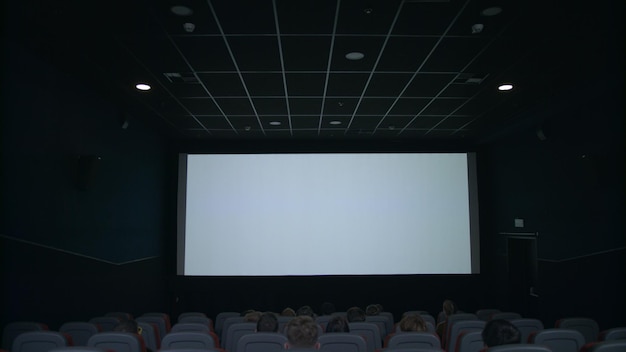 Spettatori seduti davanti allo schermo bianco Persone che applaudono al cinema