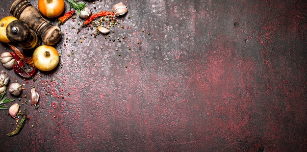 Spezie fresche Una varietà di spezie aromatiche con peperoncino e cipolle Su fondo rustico