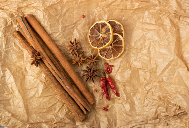 Spezie secche per vin brulè con agrumi a fette disidratati su carta kraft vintage