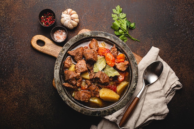 Spezzatino di carne di manzo con verdure e salsa in vista dall'alto di una pentola di metallo rustico