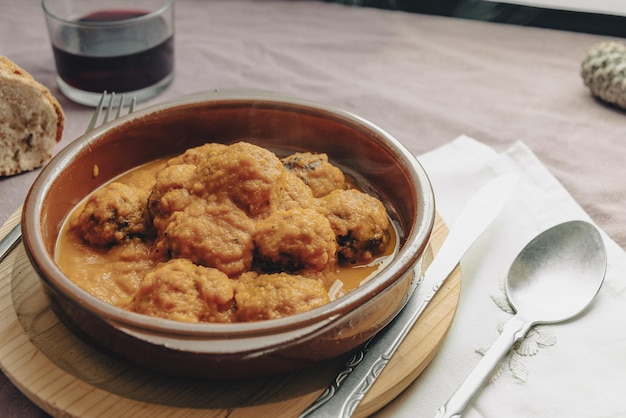 Spezzatino di polpette al sugo di pomodoro in una casseruola di coccio.