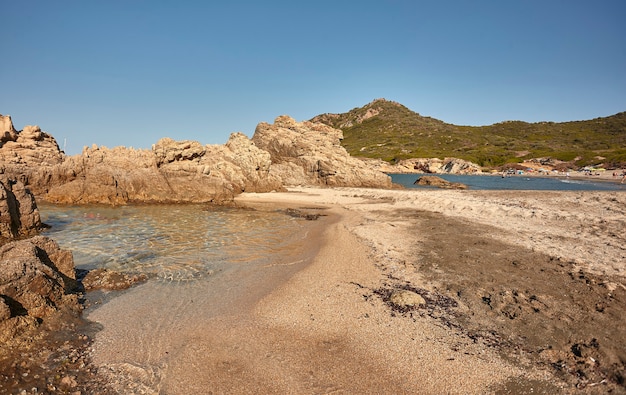 Spiaggetta rocciosa deserta del sud Sardegna in un pomeriggio d'estate di agosto