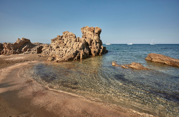 Spiaggetta rocciosa deserta del sud Sardegna in un pomeriggio d'estate di agosto