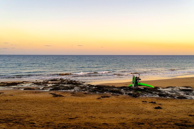 Spiaggia a Lanzarote con una donna sulla riva dopo Wing Foil. Vela e surf