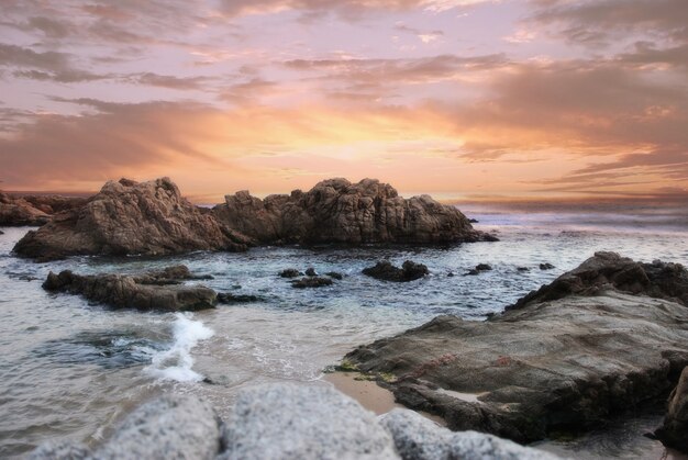 Spiaggia al tramonto con roccia