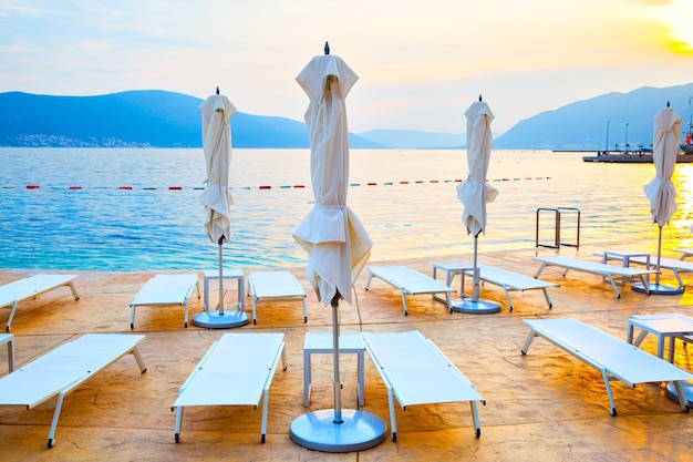 Spiaggia con sdraio e ombrelloni al tramonto, Montenegro