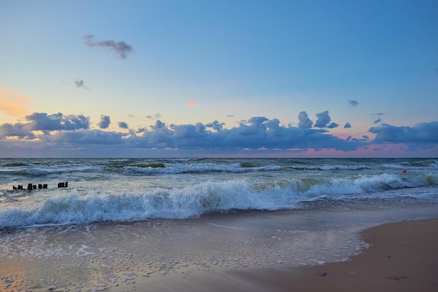 Spiaggia del Mar Baltico con onde al tramonto