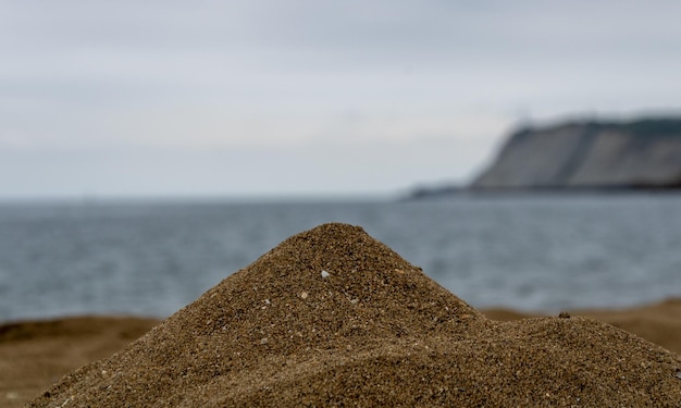 SPIAGGIA DEL NORD CON ONDE E ROCCE SOTTO CIELI NUVOLI DI PRIMAVERA