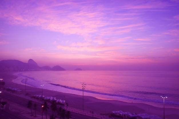 Spiaggia di Copacabana di colore viola in stile surreale pop art al tramonto nella città di Rio de Janeiro in Brasile