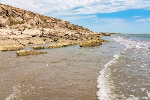 Spiaggia di mare rocciosa vuota con piccole onde