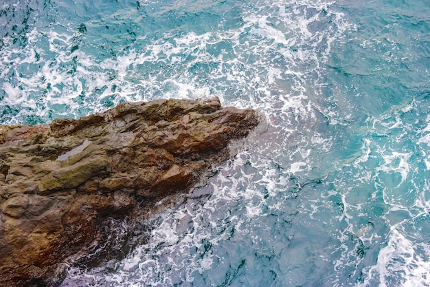 Spiaggia di pietra scogliera SANDANBEKI con sventolando mare blu.