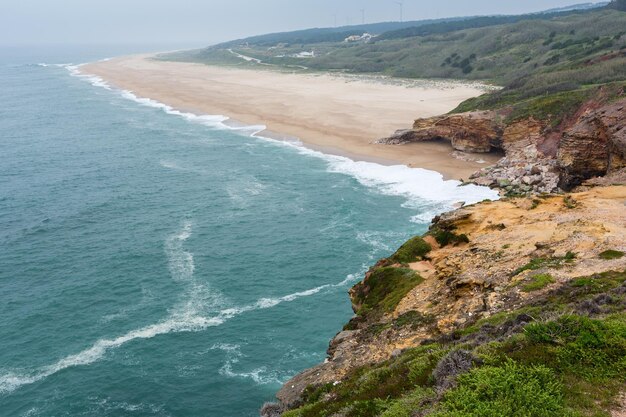 Spiaggia di sabbia dell'oceano vicino alla città di Nazare (Portogallo).