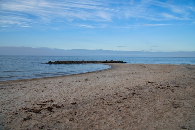 Spiaggia di sabbia sulla costa della Danimarca Groyne di pietra nella baia sole mentre si cammina