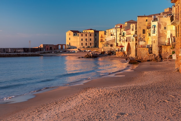 Spiaggia di sabbia vuota nel centro storico della città costiera Cefalù al tramonto, Sicilia, Italy