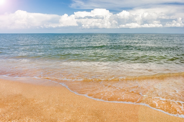 Spiaggia e cielo blu tropicali marini della sabbia con le nuvole