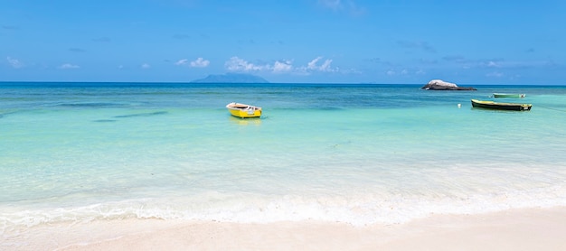 Spiaggia estiva con cielo soleggiato e sfondo di acqua blu water