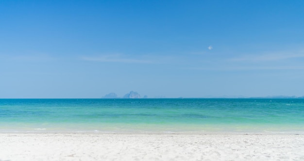 Spiaggia limpida con sfondo di montagna e bel cielo azzurro