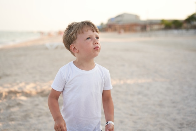 Spiaggia permanente del ragazzo caucasico