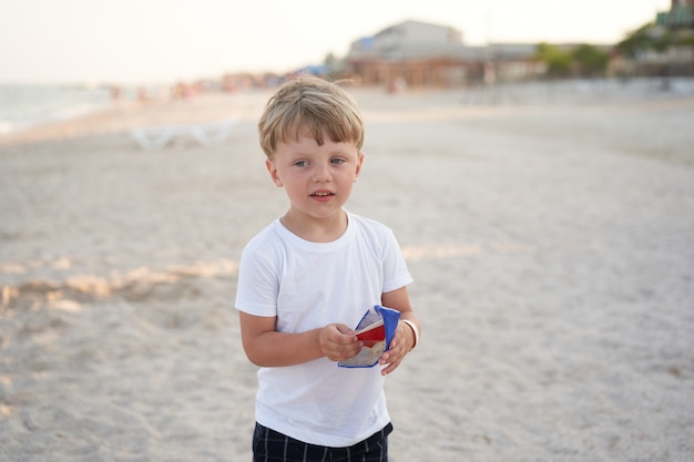 Spiaggia permanente del ragazzo caucasico