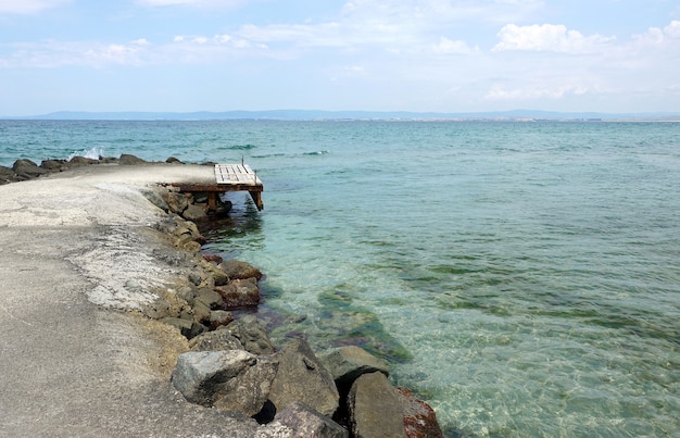 spiaggia rocciosa con un vecchio molo