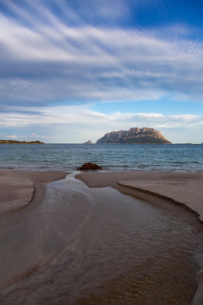 Spiaggia rocciosa e sabbiosa a Porto Istana Sardegna Italia Isola di Tavolara sullo sfondo