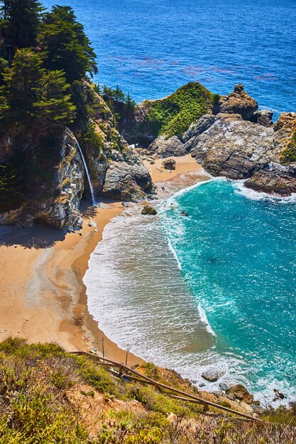 Spiaggia sabbiosa con cascata nell'acqua dell'oceano