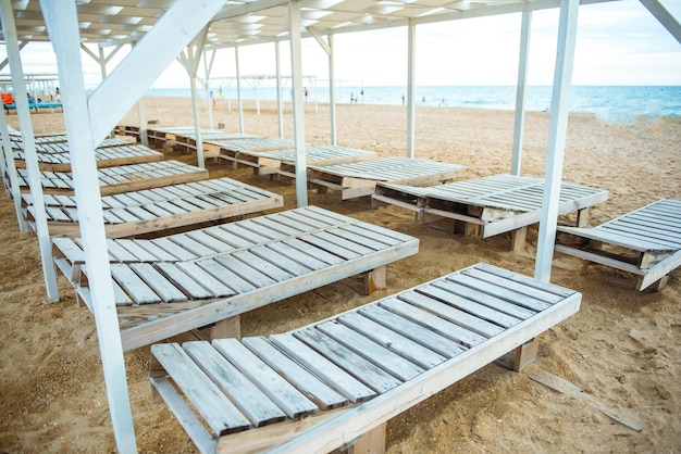 Spiaggia sabbiosa con lettini e tettoia in legno in un resort tropicale sulla costa del mare Quarantena