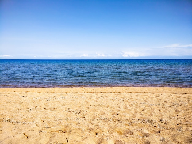 Spiaggia sabbiosa Oceano calmo Cielo blu. Sfondo di orizzonte