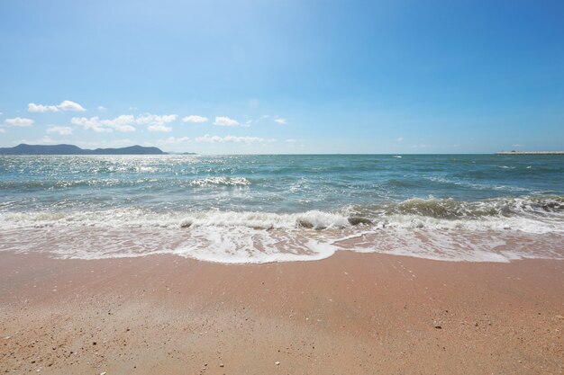 Spiaggia sabbiosa pulita e vuota con la piccola onda sulle vacanze estive usando per il fondo della natura. Concetto di vacanza di viaggio