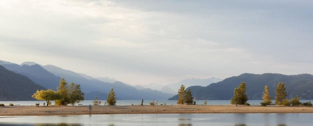 Spiaggia sabbiosa sul lago con il paesaggio montano canadese sullo sfondo