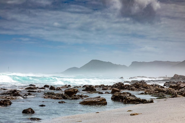 Spiaggia sabbiosa sul lato occidentale della penisola di Città del Capo in una giornata nuvolosa