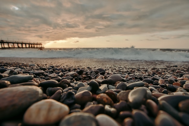 Spiaggia sassosa dopo il tramonto. Bellissima spiaggia piena di ciottoli nel litorale