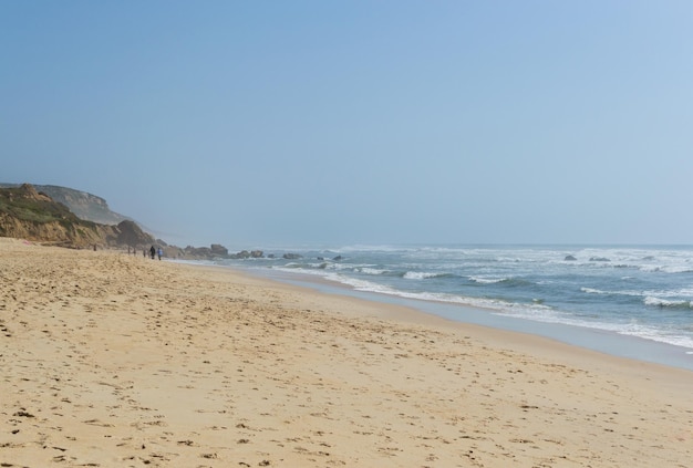 Spiaggia sull'oceano con persone che riposano luogo di vacanza Montagne, mare e onde Viaggio in Europa Portogallo