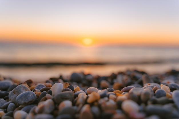 Spiaggia tranquilla e calma al tramonto Bellissimi ciottoli strutturati in primo piano Il concetto di serenità